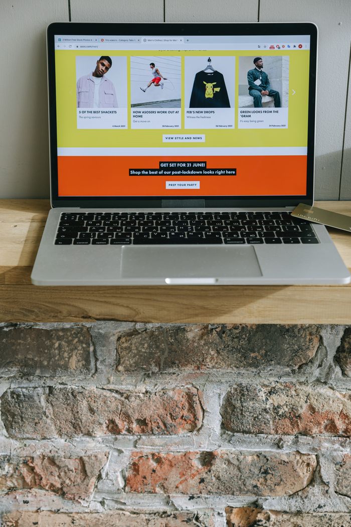 Notebook na dřevěné polici zobrazující barevnou stránku online nakupování.